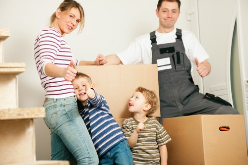 Careful wrapping of fragile household items during a packing service in Merton